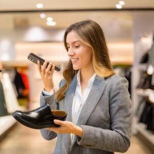 department store sales associate uses push to talk app to talk to colleague to fetch a particular shoe size